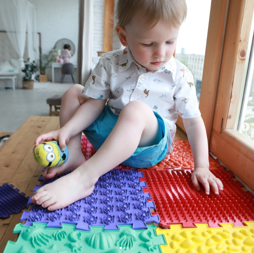 Chlapeček si hraje na barevných puzzle podložkách Krůček