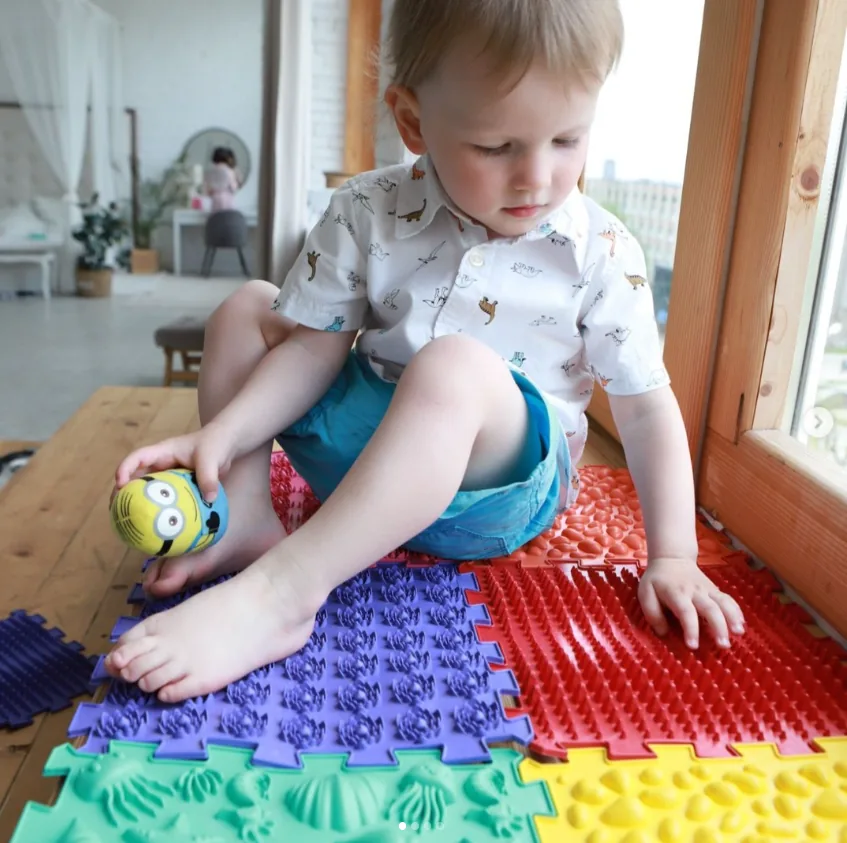 Chlapeček si hraje na barevných puzzle podložkách Krůček